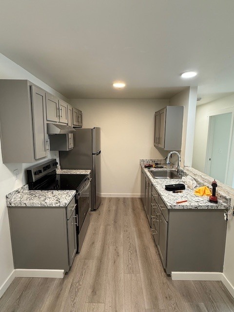 Renovated apartment kitchen with new cabinets, counters, appliances, and flooring